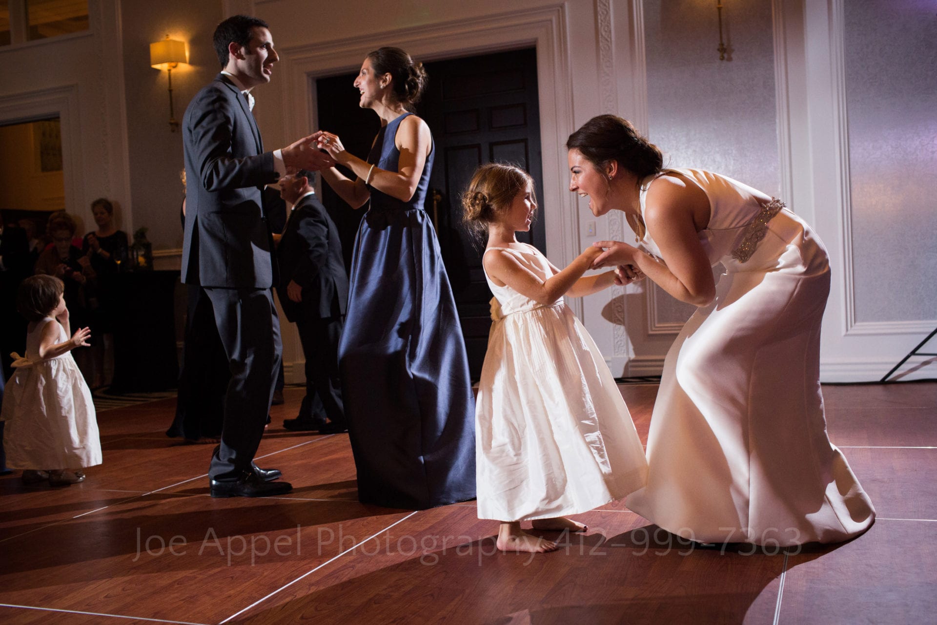 the bride dances with a little girl in a white dress