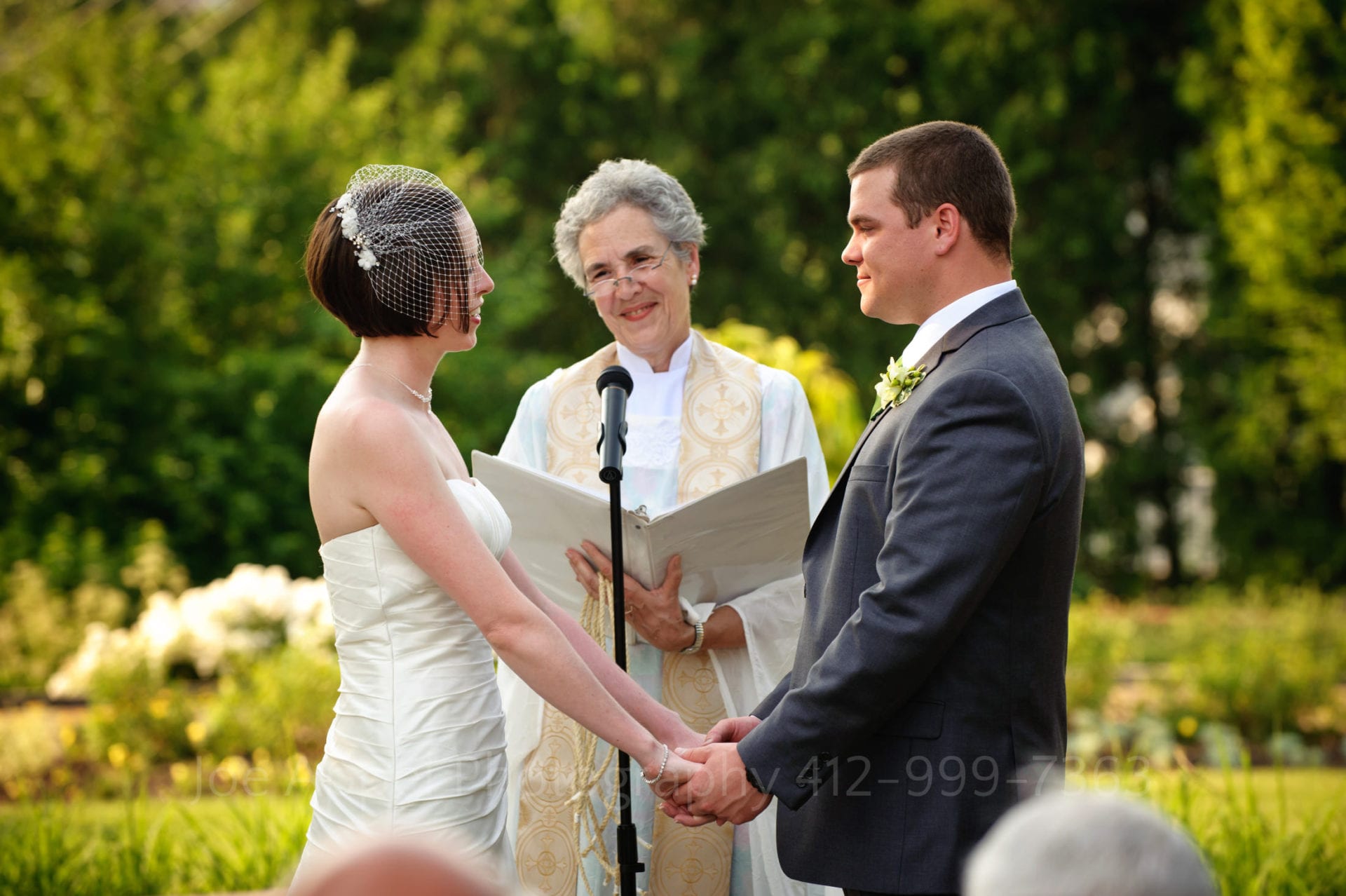 a bride and groom say their vows in a green garden with trees Phipps Conservatory Weddings