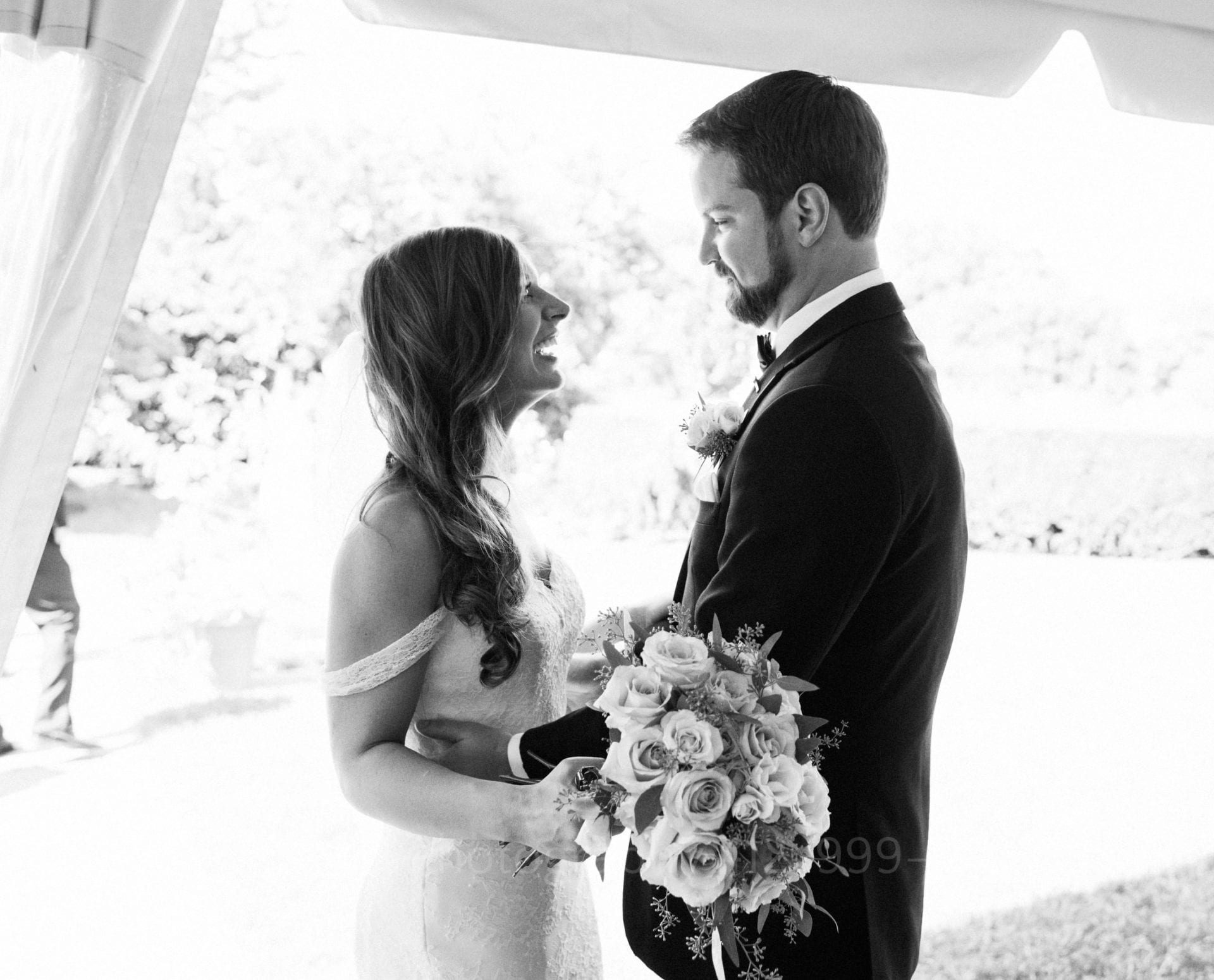 a bride smiles as her groom embraces her Phipps Conservatory Weddings