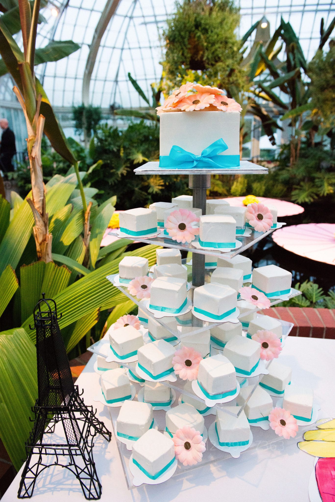white and blue pastries sit on a cake stand with pink flowers Phipps Conservatory Weddings