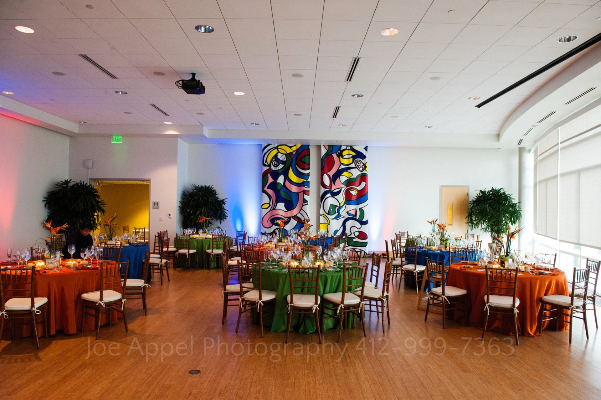 blue orange and green tables in front of colorful tapestries Phipps Conservatory Weddings