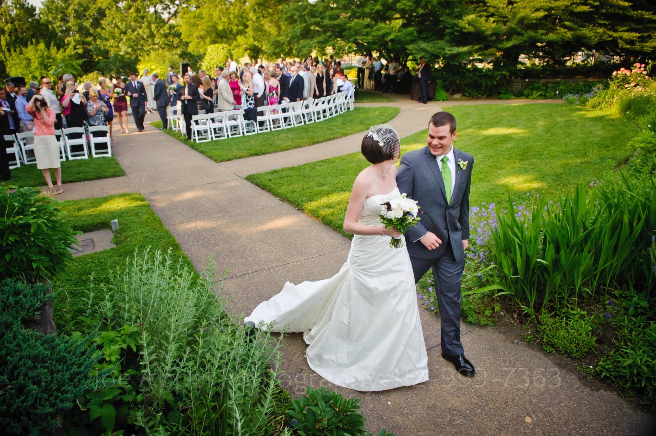 a bride and groom walk through a grassy area Phipps Conservatory Weddings