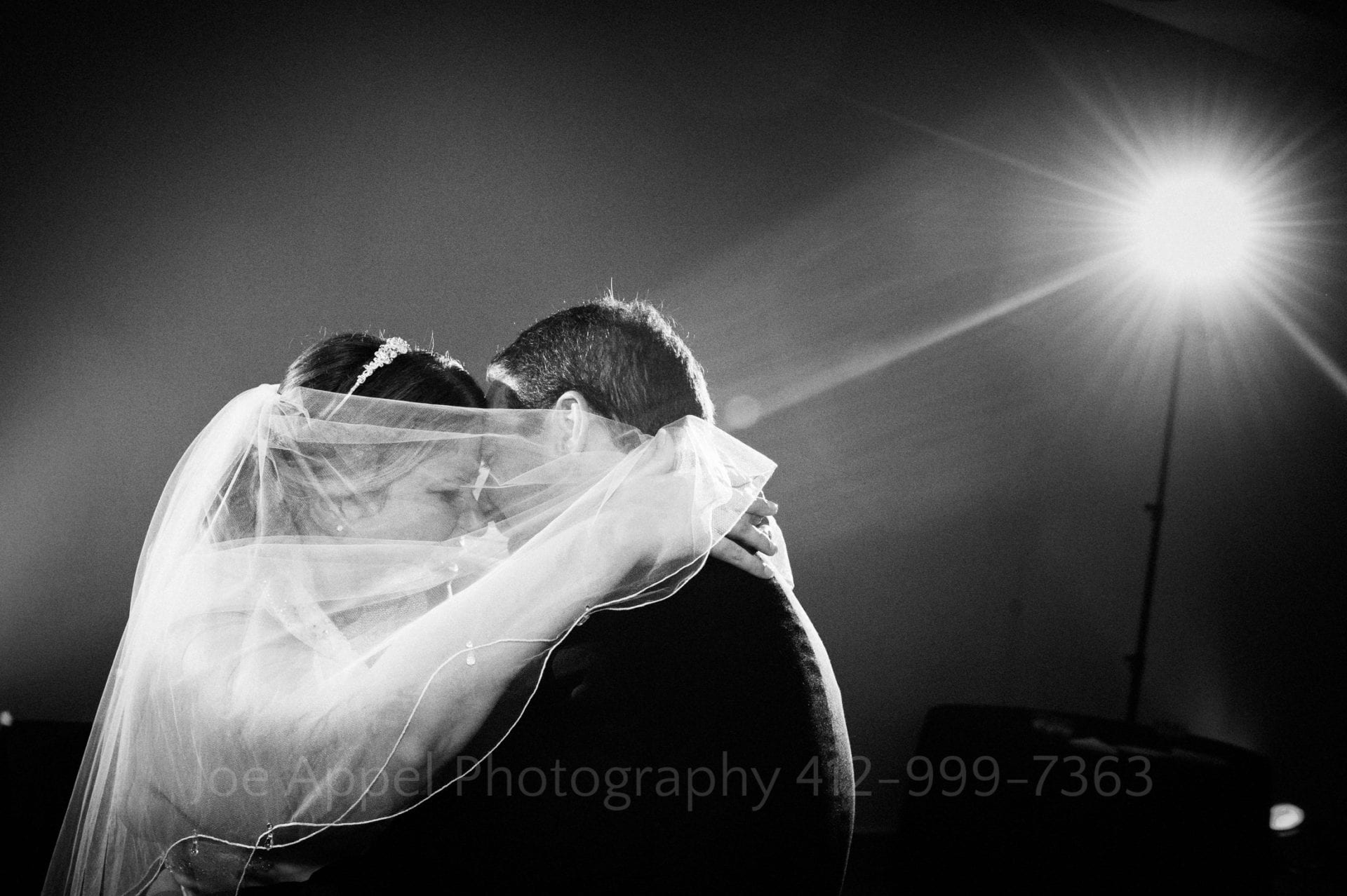 a bride wraps her veil around her groom as they dance Phipps Conservatory Weddings