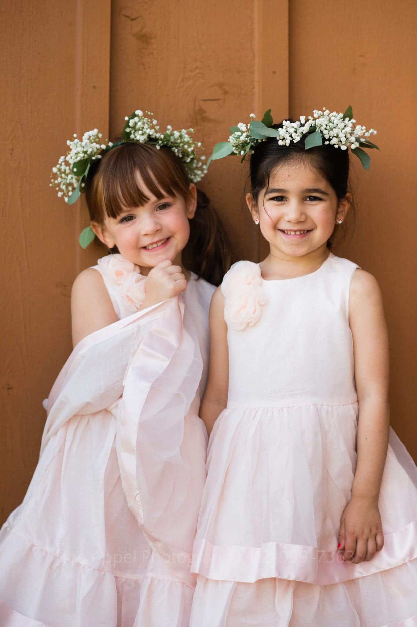 two flower girls in pink dresses and green flower crowns Seven Springs Weddings