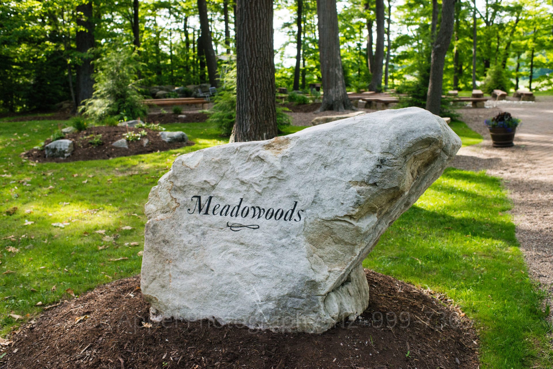a sign for meadowoods is engraved on a rock in a forest Seven Springs Weddings