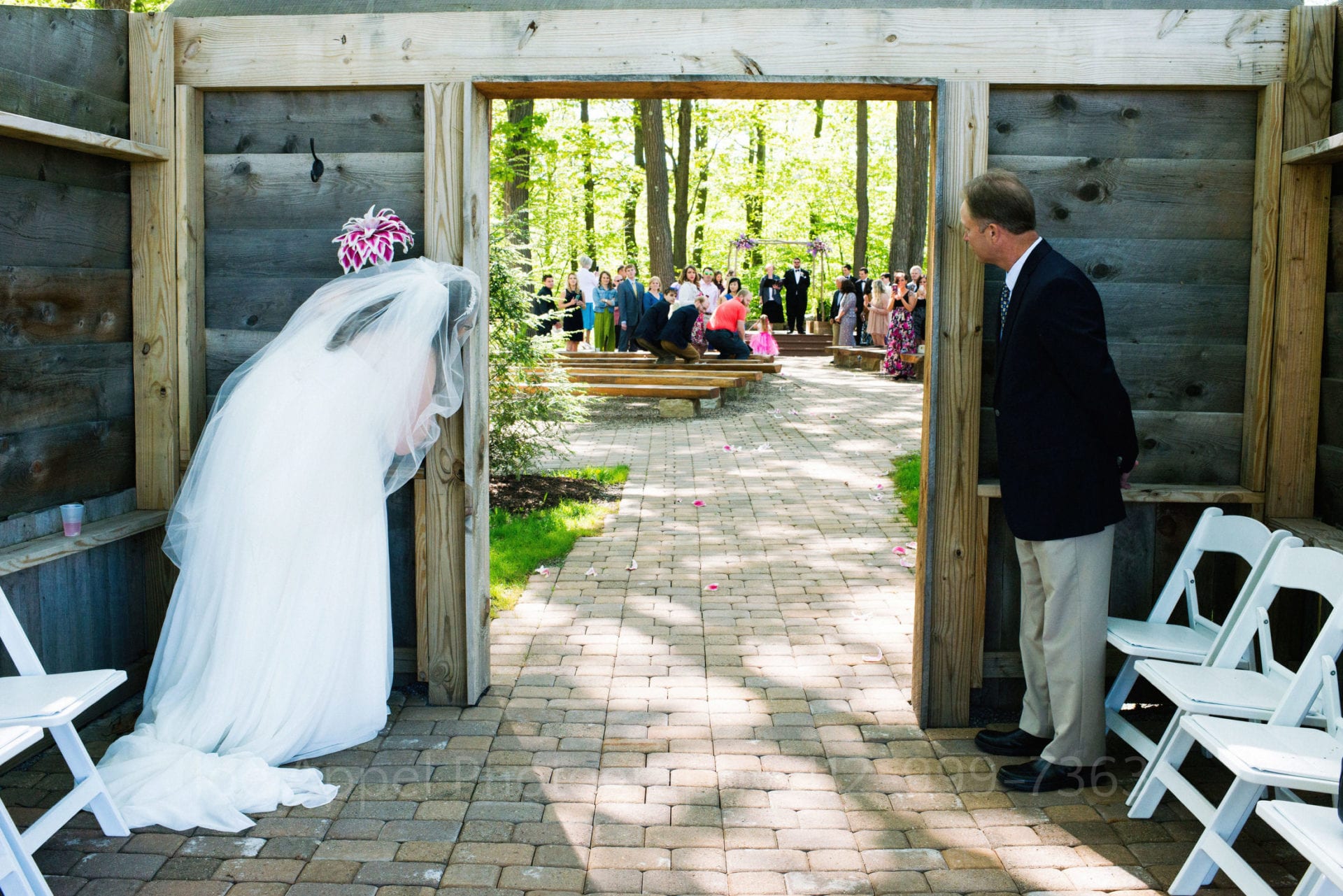 a bride and her father hide behind a wall and spy on guests Seven Springs Weddings