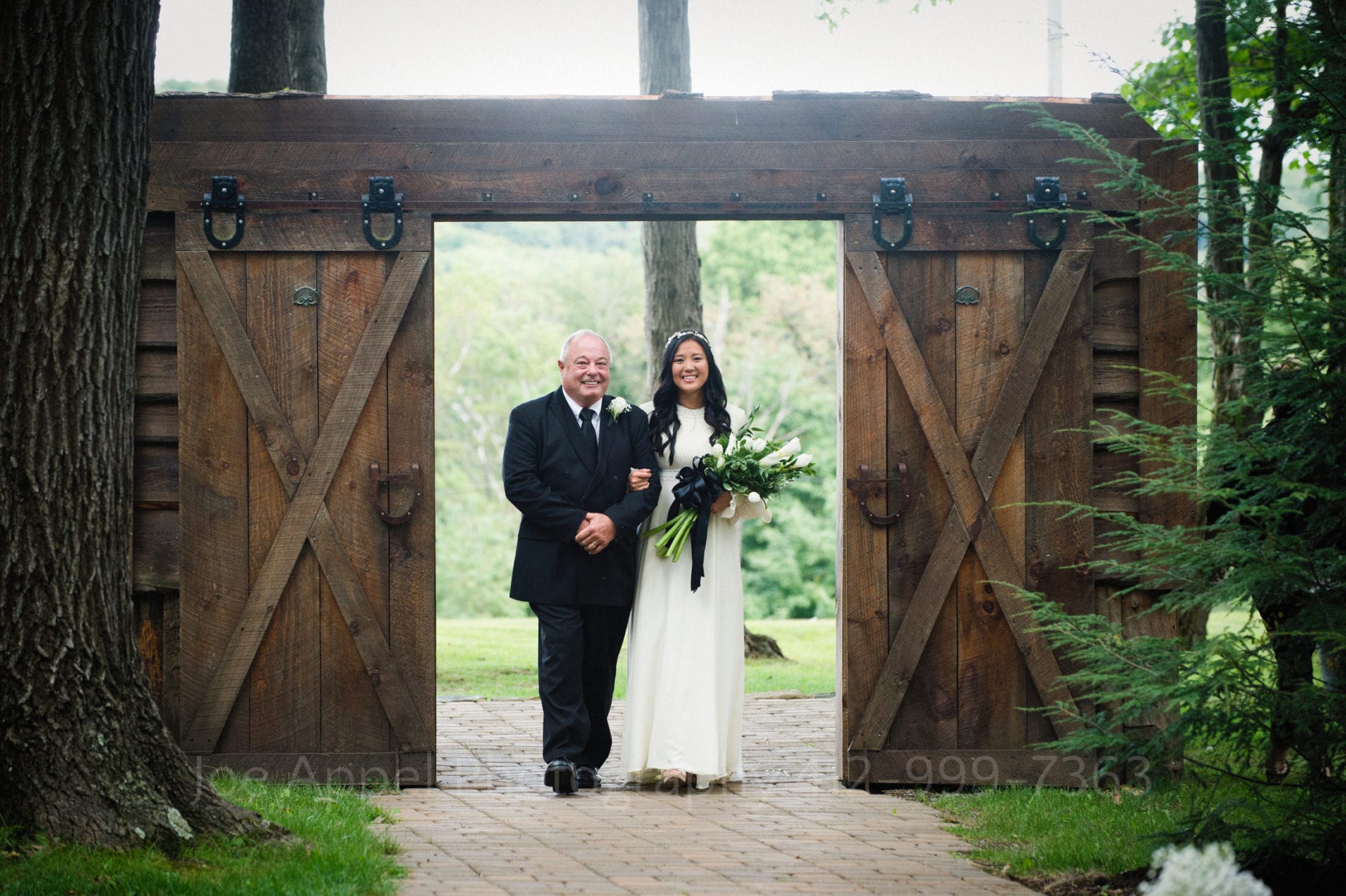 a bride and her father smile as they walk down the aisle together Seven Springs Weddings