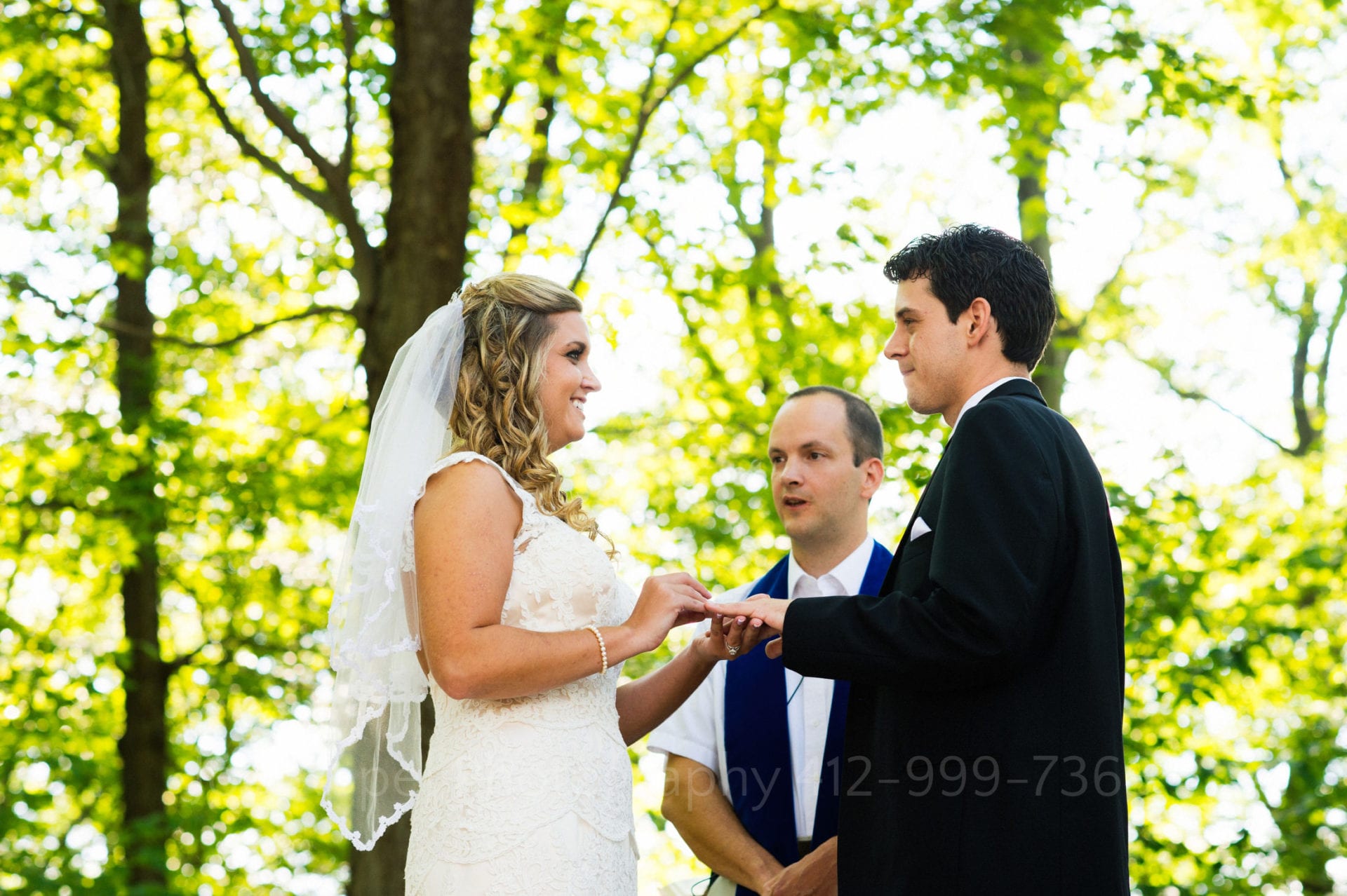 a bride and groom say their vows in front of an illuminated green forest Seven Springs Weddings