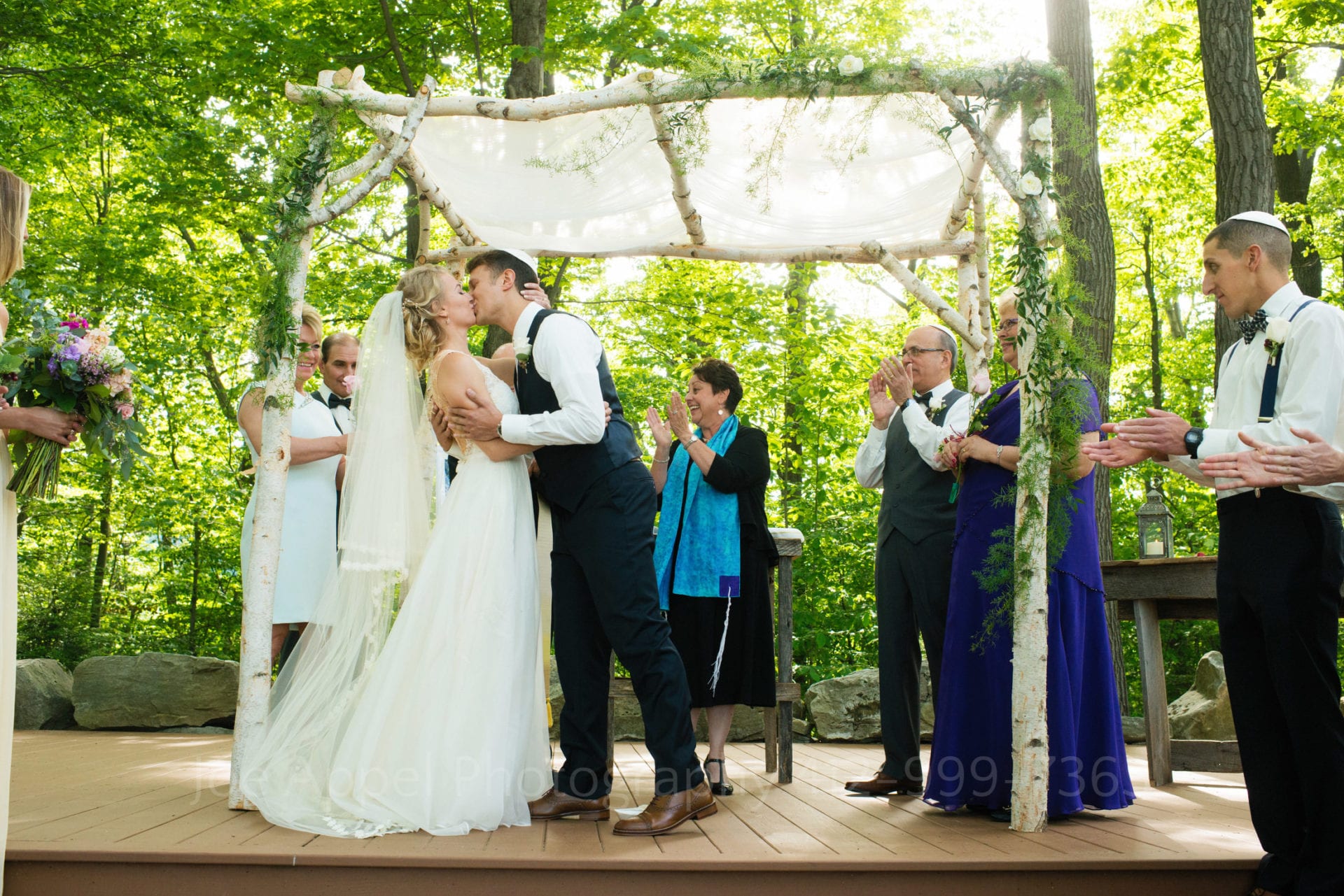 guests clap as the bride and groom kiss Seven Springs Weddings