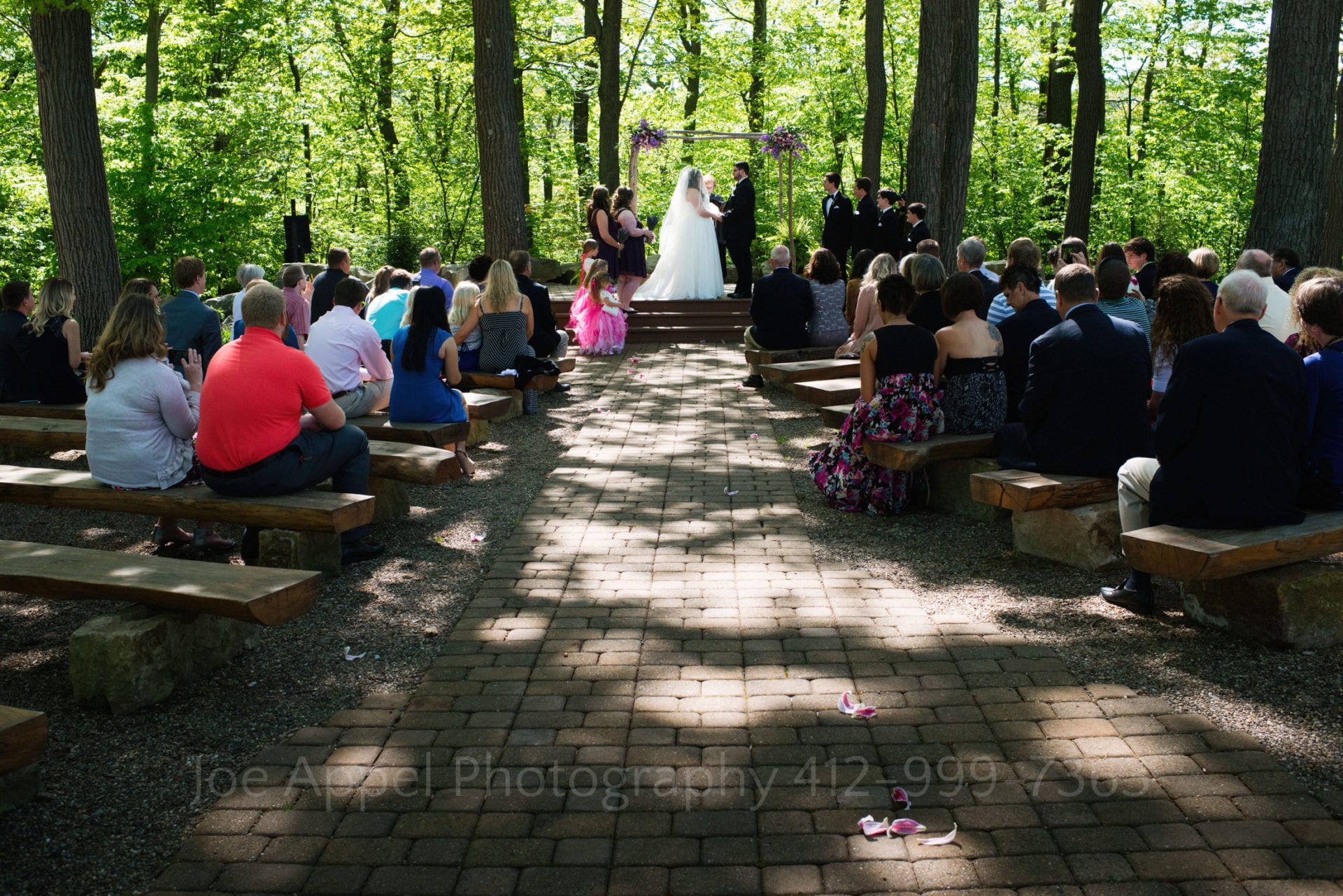 a bride and groom stand under their chuppah with pink flowers Seven Springs Weddings