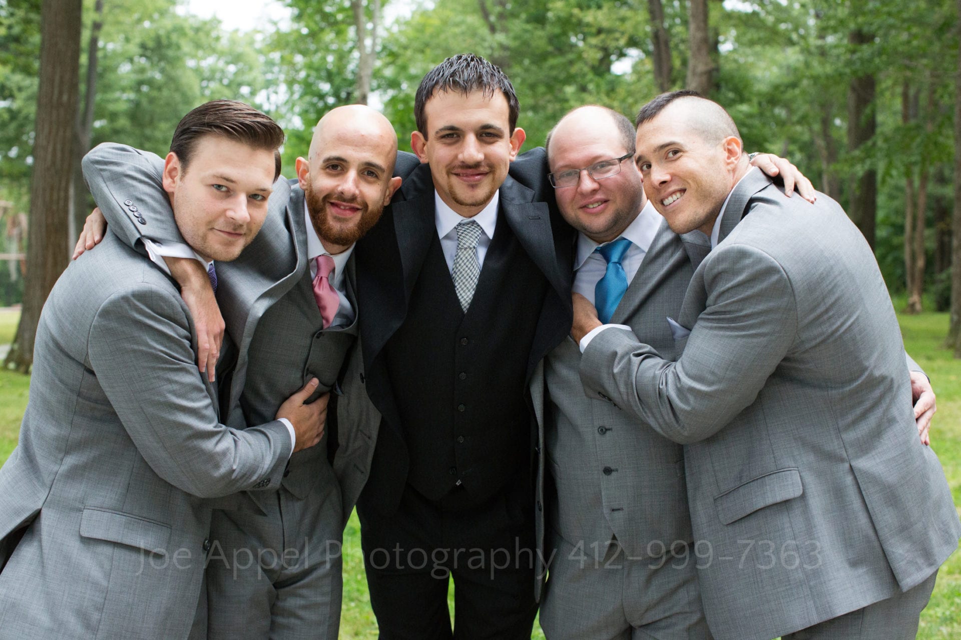a groom embraces his groomsmen Seven Springs Weddings