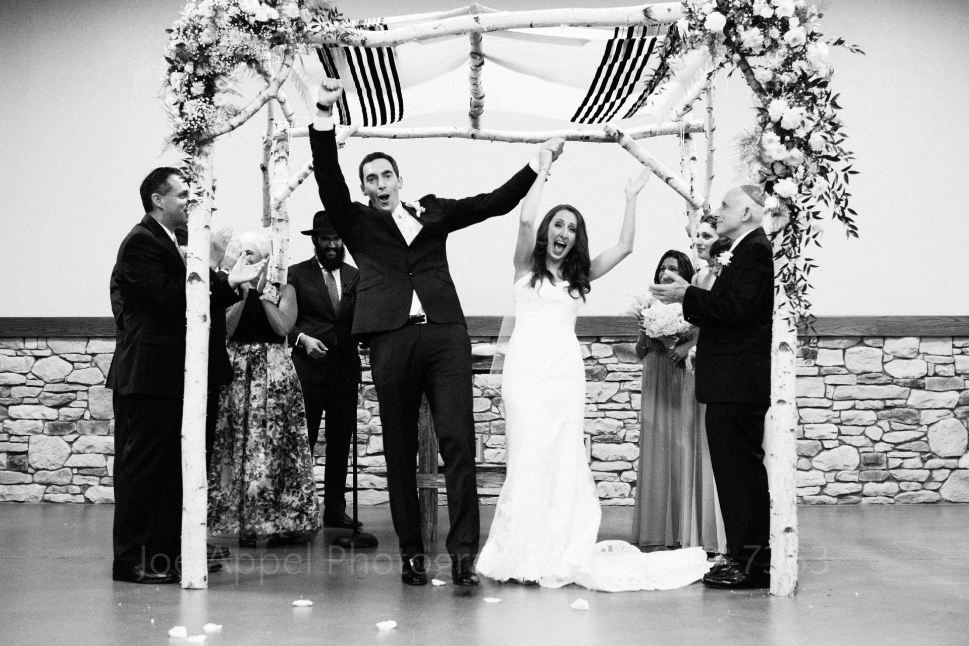 a bride and groom stand under their chuppah and cheer Seven Springs Weddings