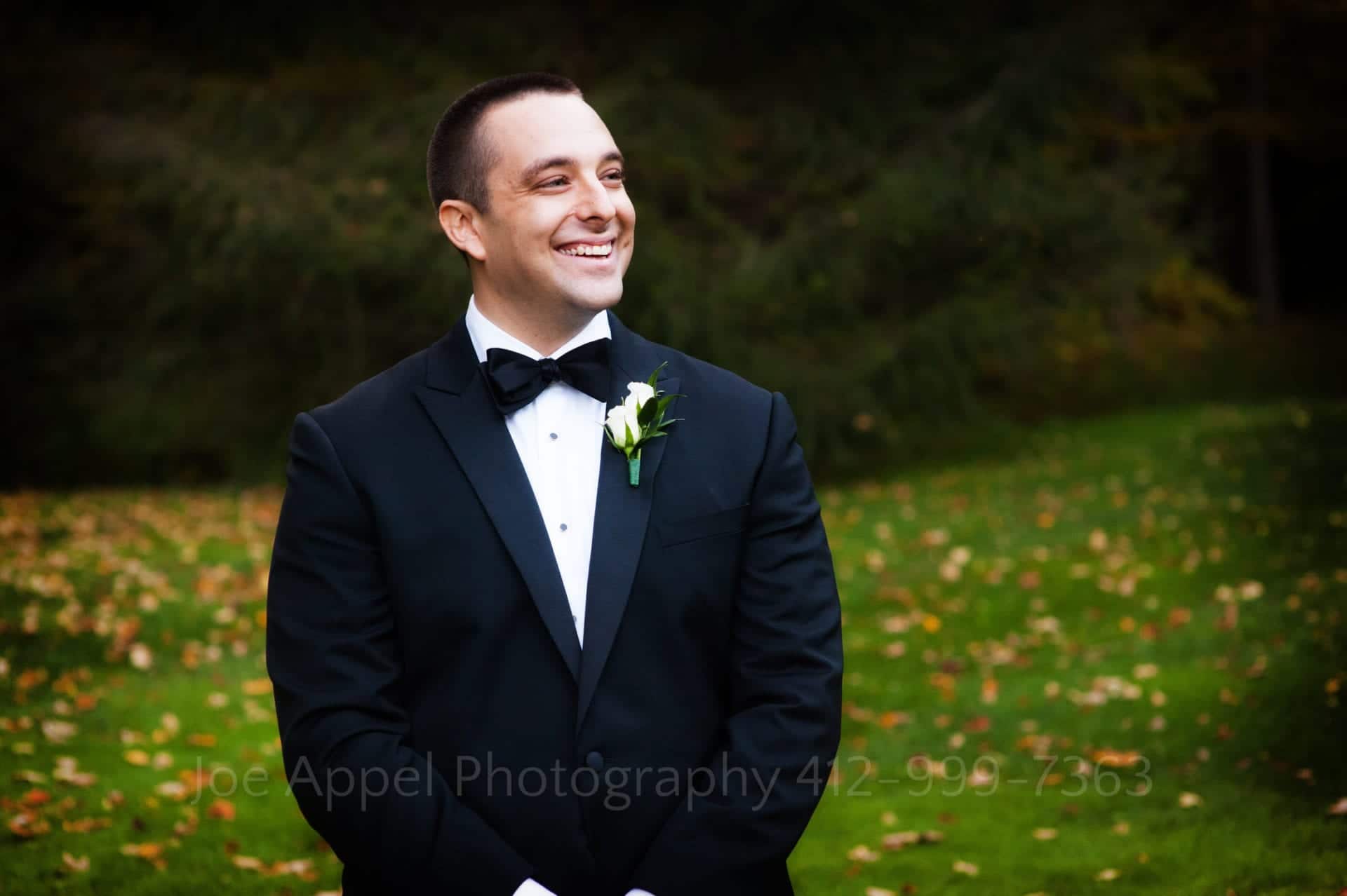 a groom smiles as he watches his bride Seven Springs Weddings