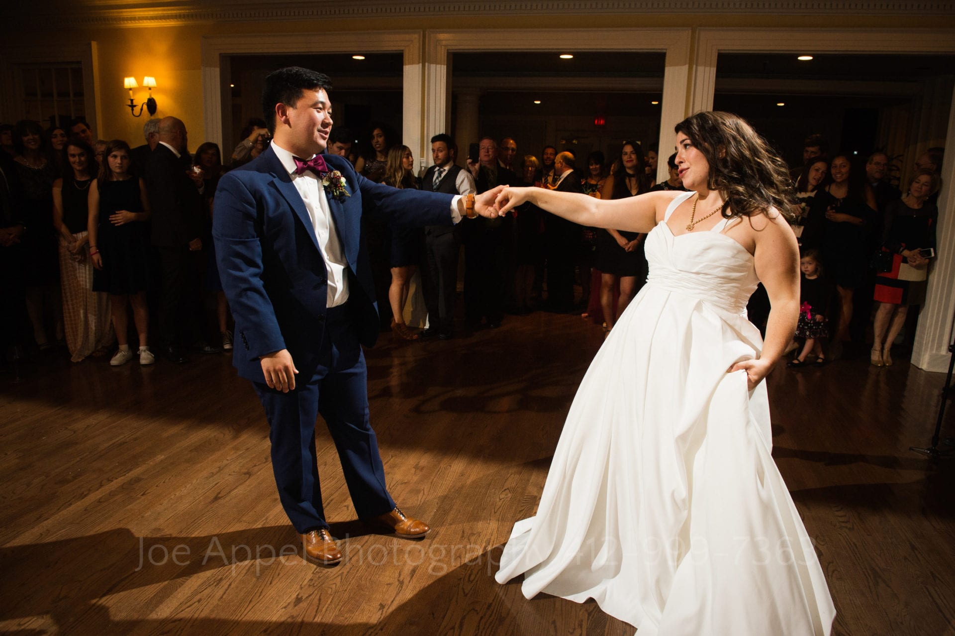 a bride and groom sing and dance while guests watch