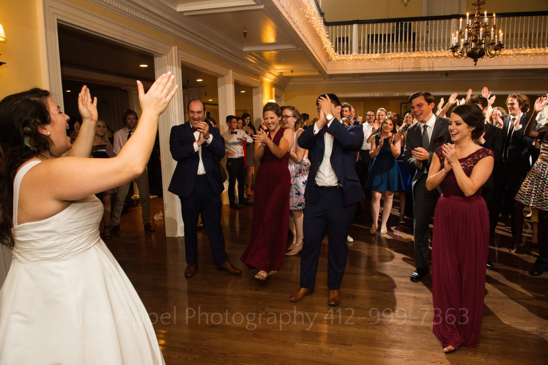 a bride laughs and leads her guests in a dance