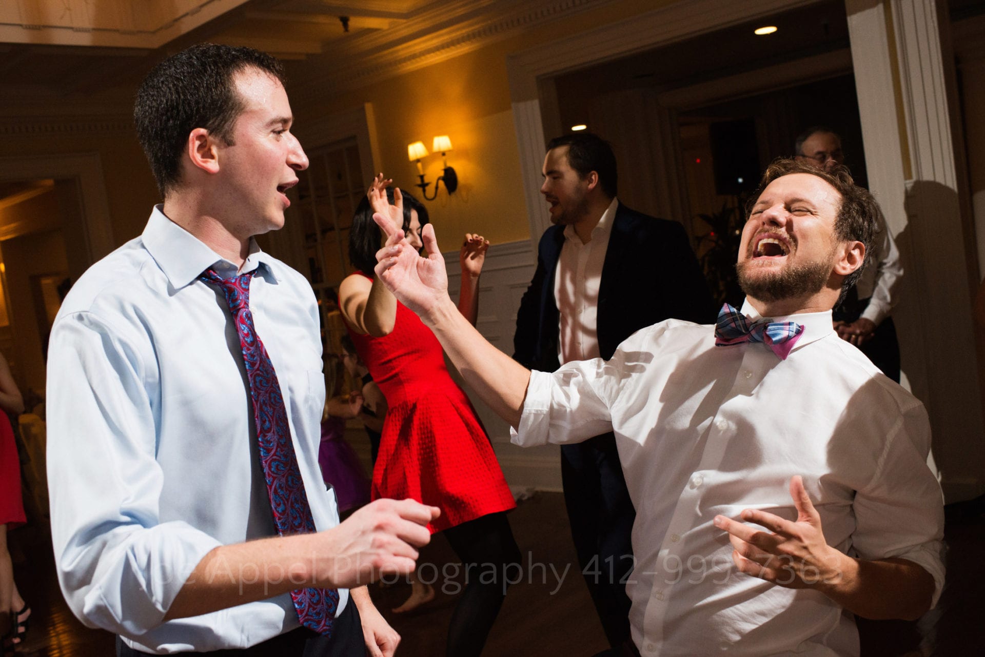 two men in red and blue ties yell and dance