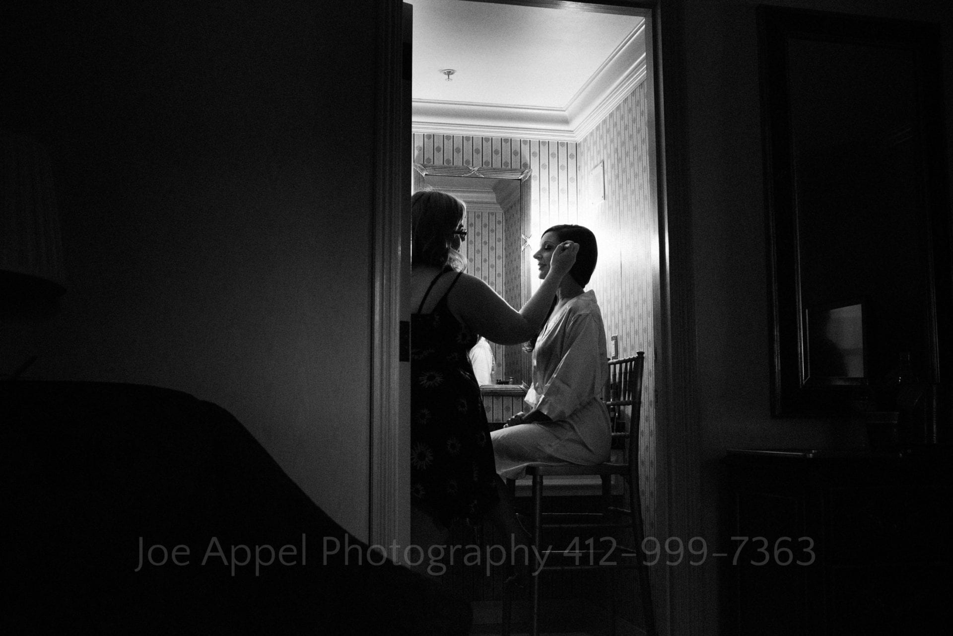 a bridesmaid gets her makeup done in a bathroom