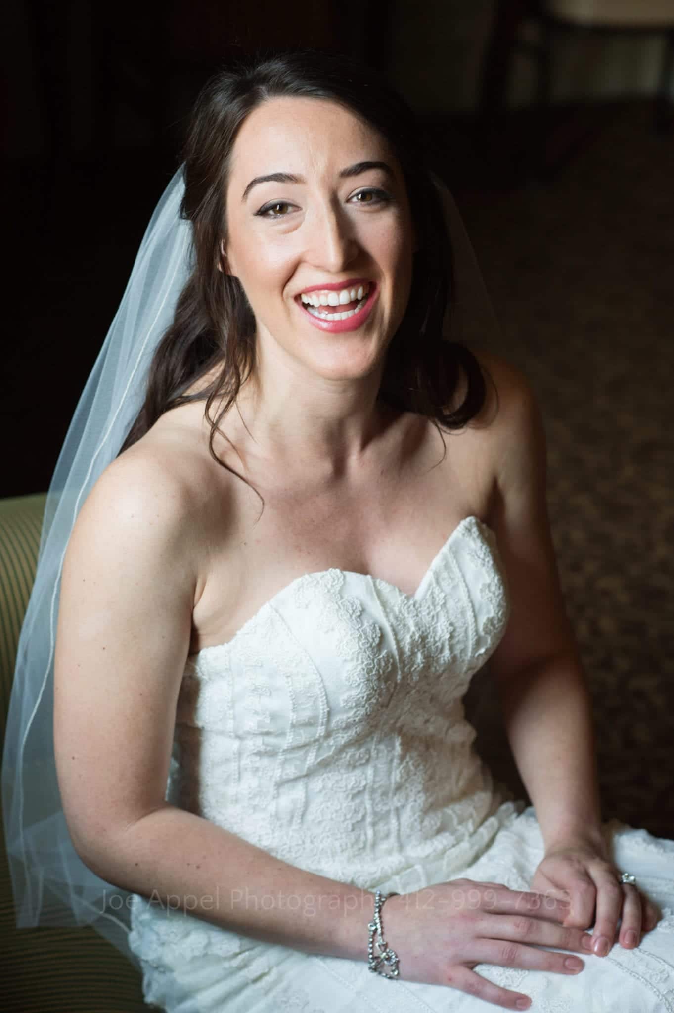 a smiling bride in a white detailed dress