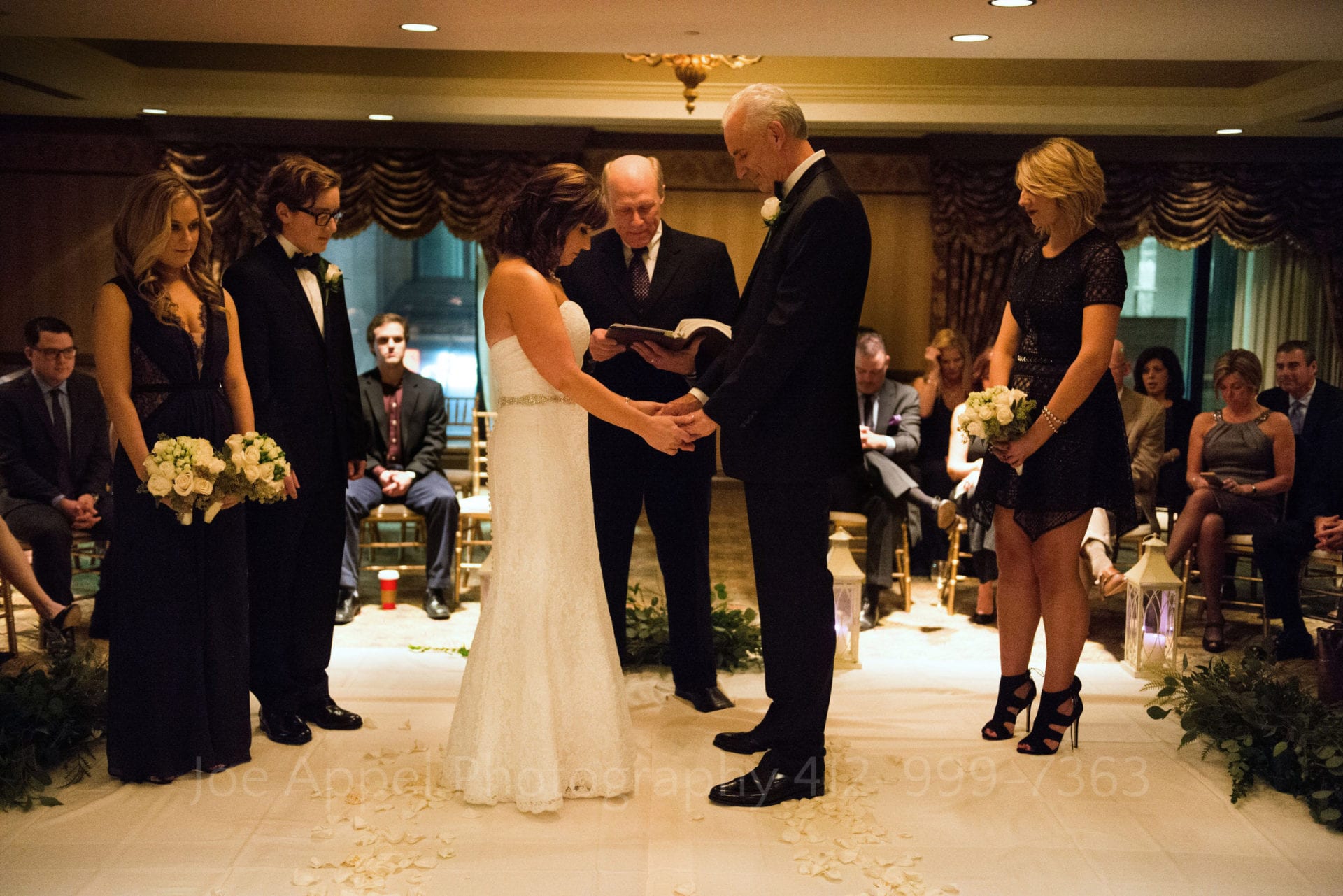 guests surround a bride and groom saying their vows