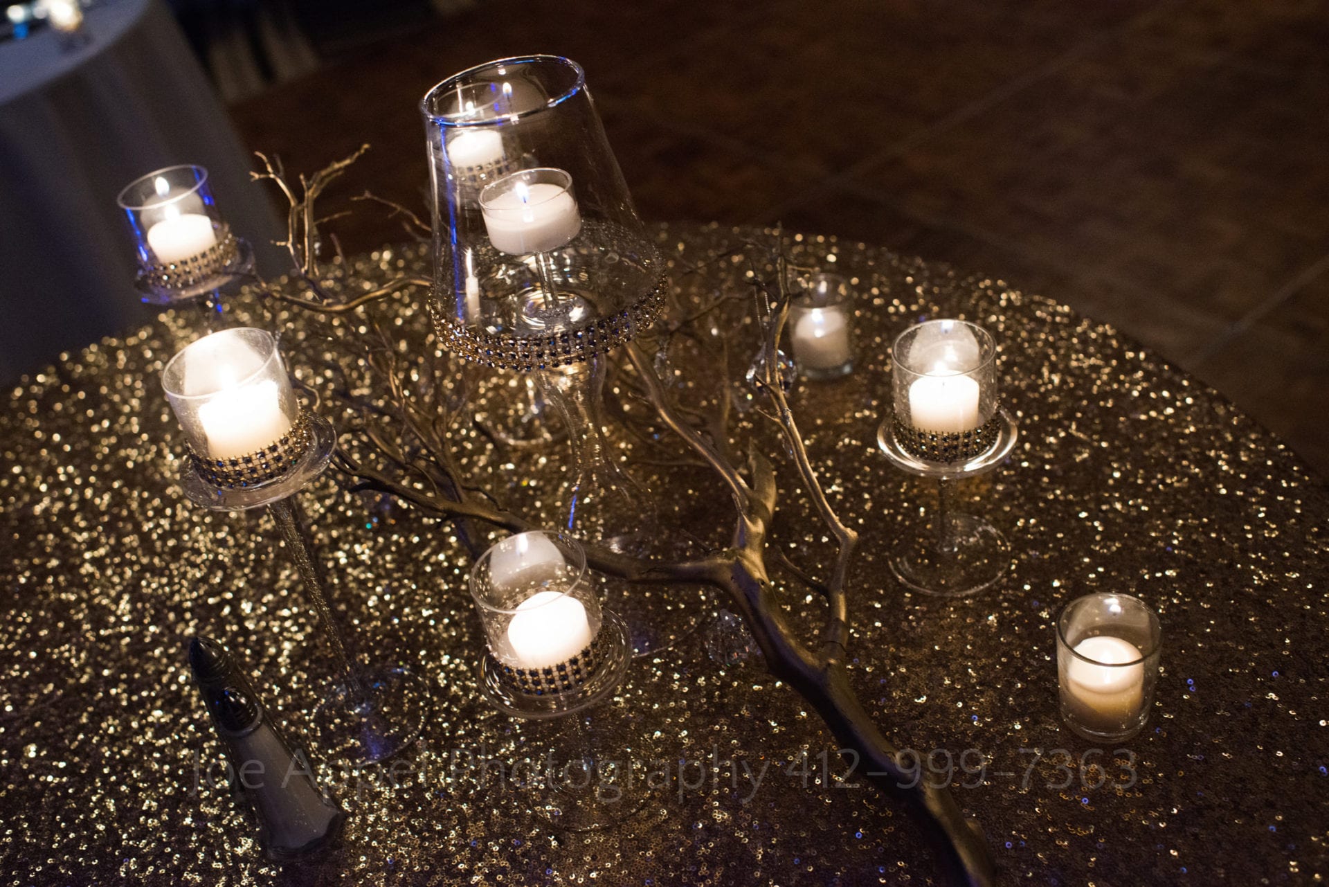 gold branch centerpieces with candles on a bed of gold glitter