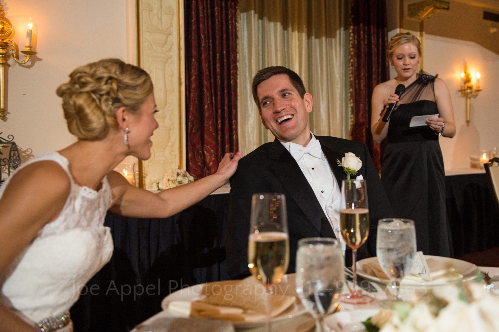 a bride laughs and touches her grooms shoulder