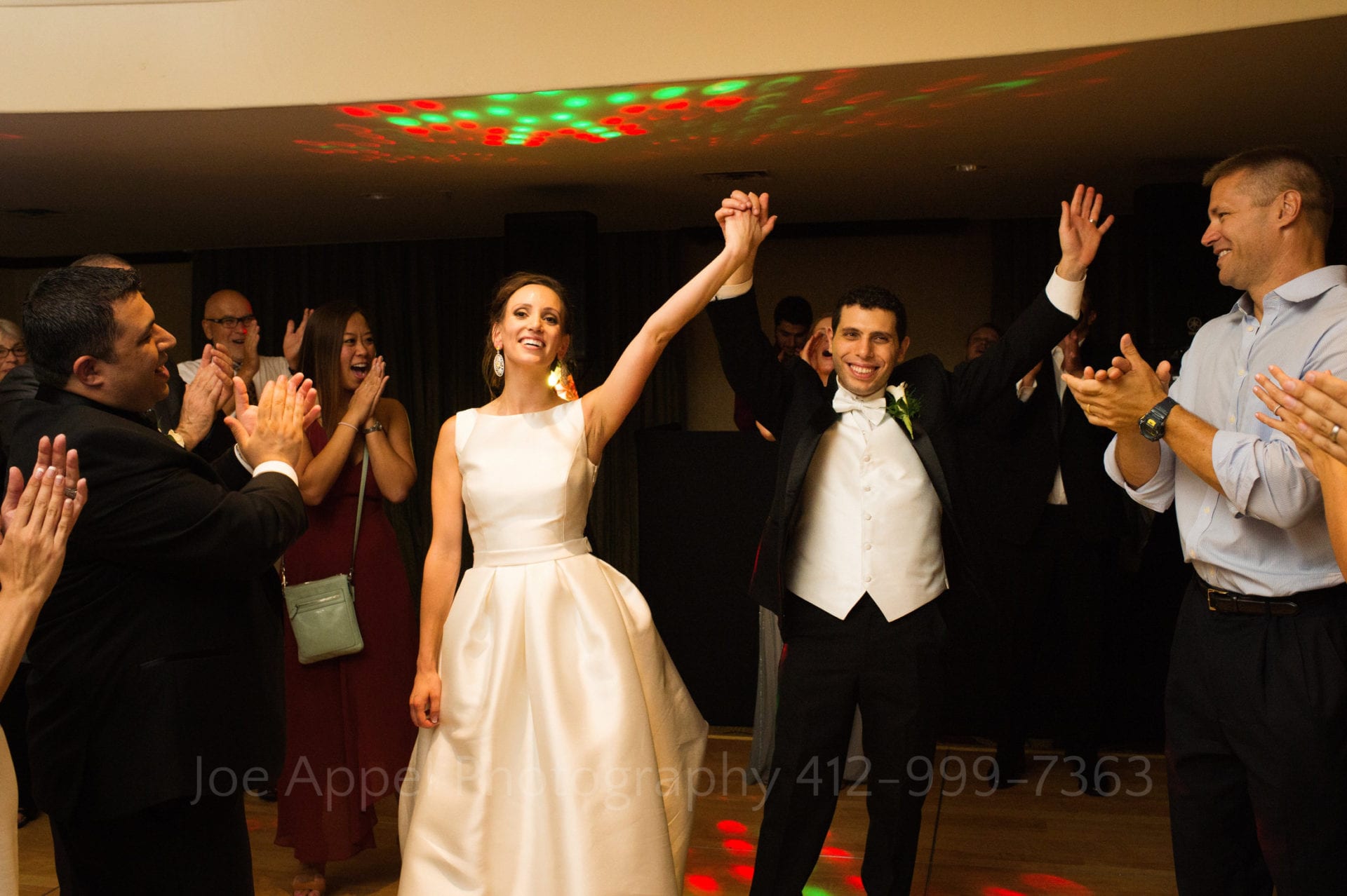 guests clap as a bride and groom enter the venue