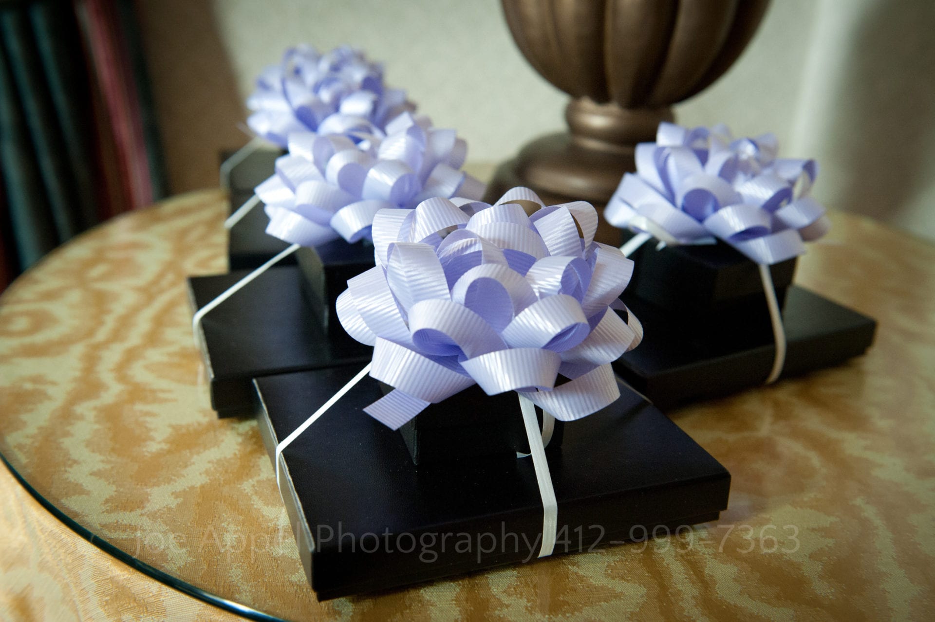 four gifts in black boxes are topped by purple bows waiting for bridesmaids at an Omni William Penn weddings