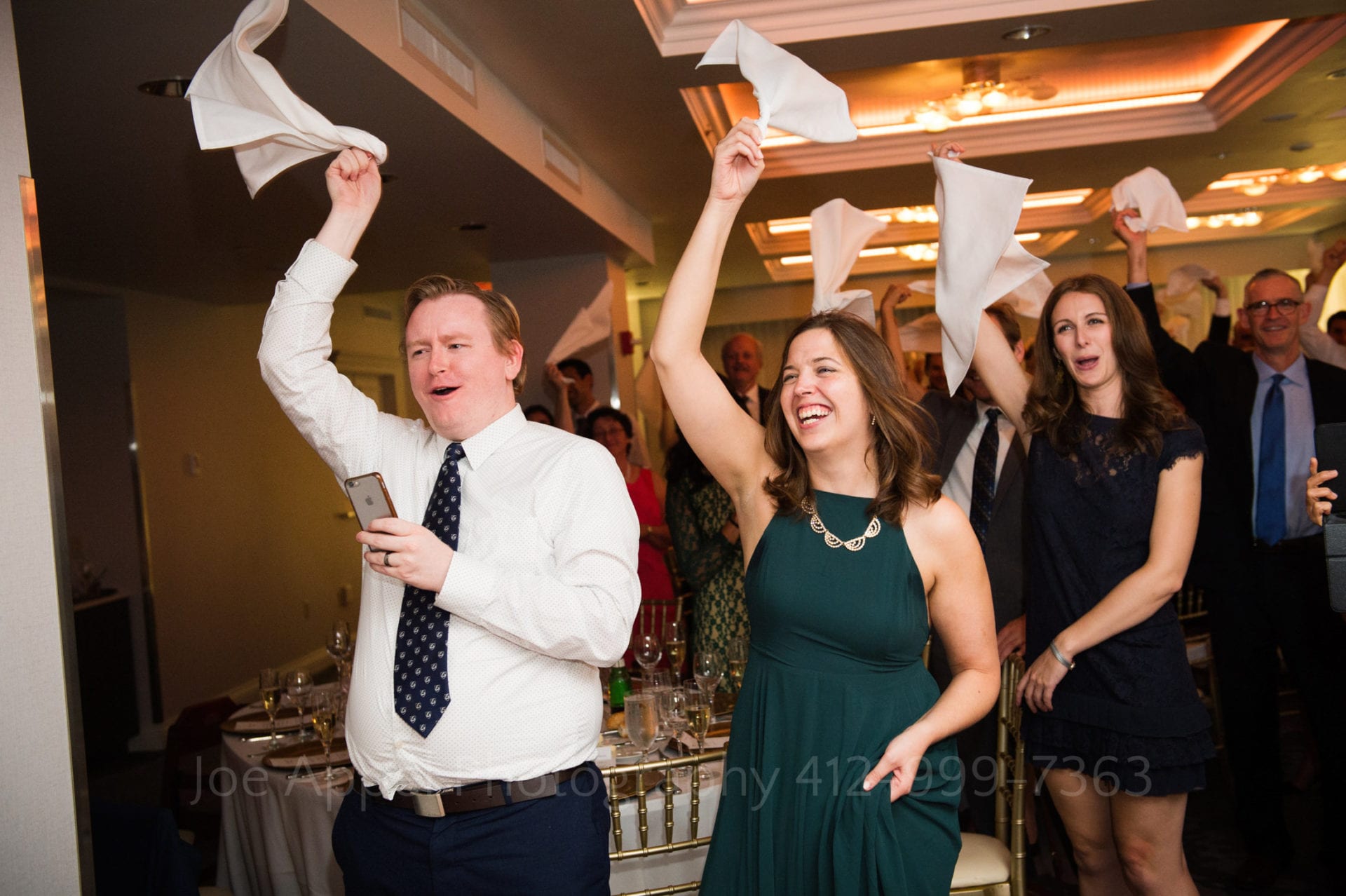 guests cheer and wave white napkins