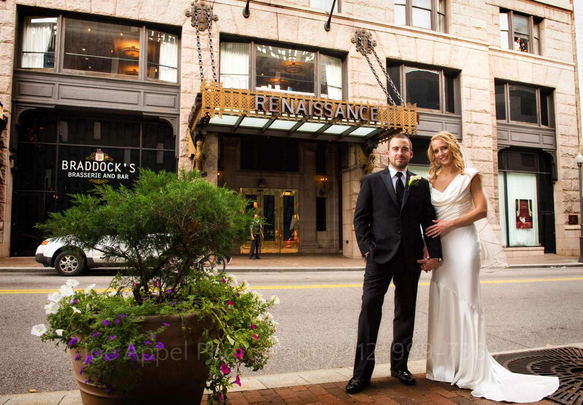 a bride and groom stand outside of the renaissance hotel in pittsburgh
