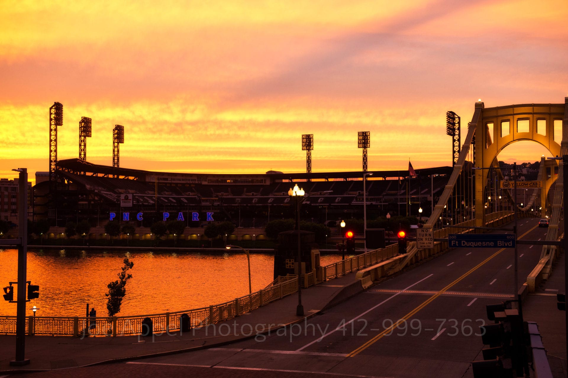 an orange yellow and pink sunset over pnc park