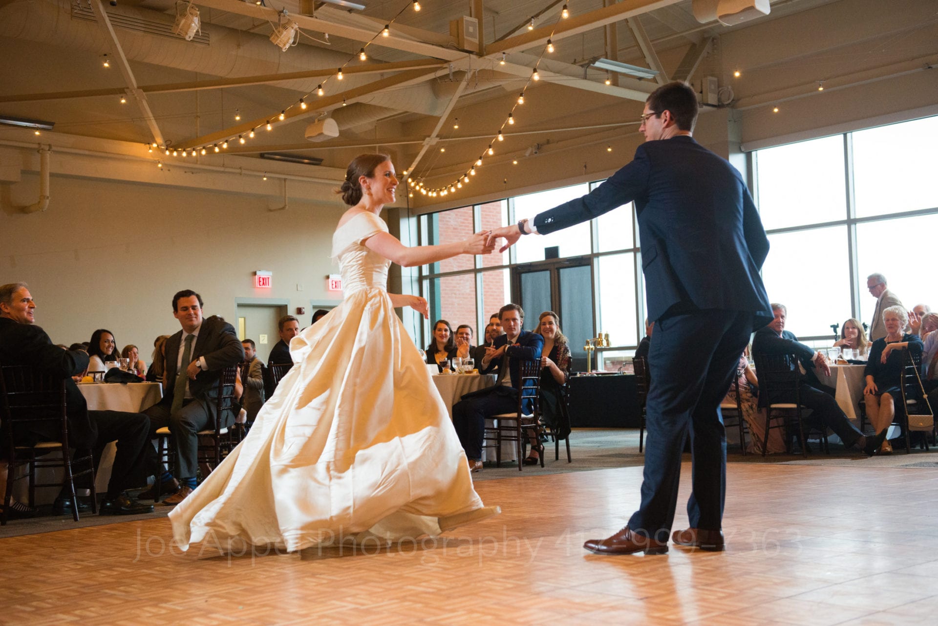A groom reaches out his arm as he spins his wife during the first dance at their Heinz History Center wedding.