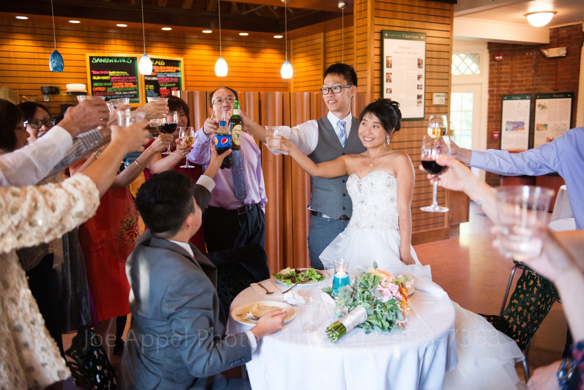 a bride and groom toast with their wedding guests at the Schenley Park cafe and visitors center