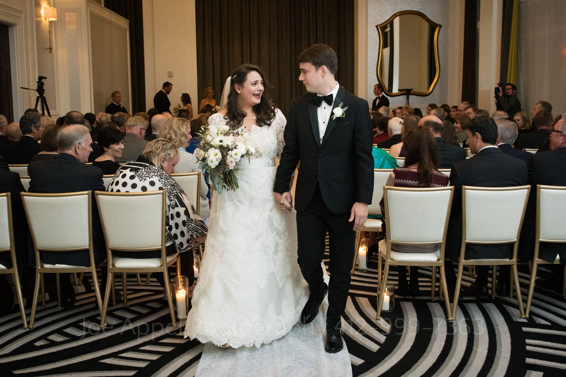 guests watch the bride and groom walk down the aisle at the hotel monaco pittsburgh wedding