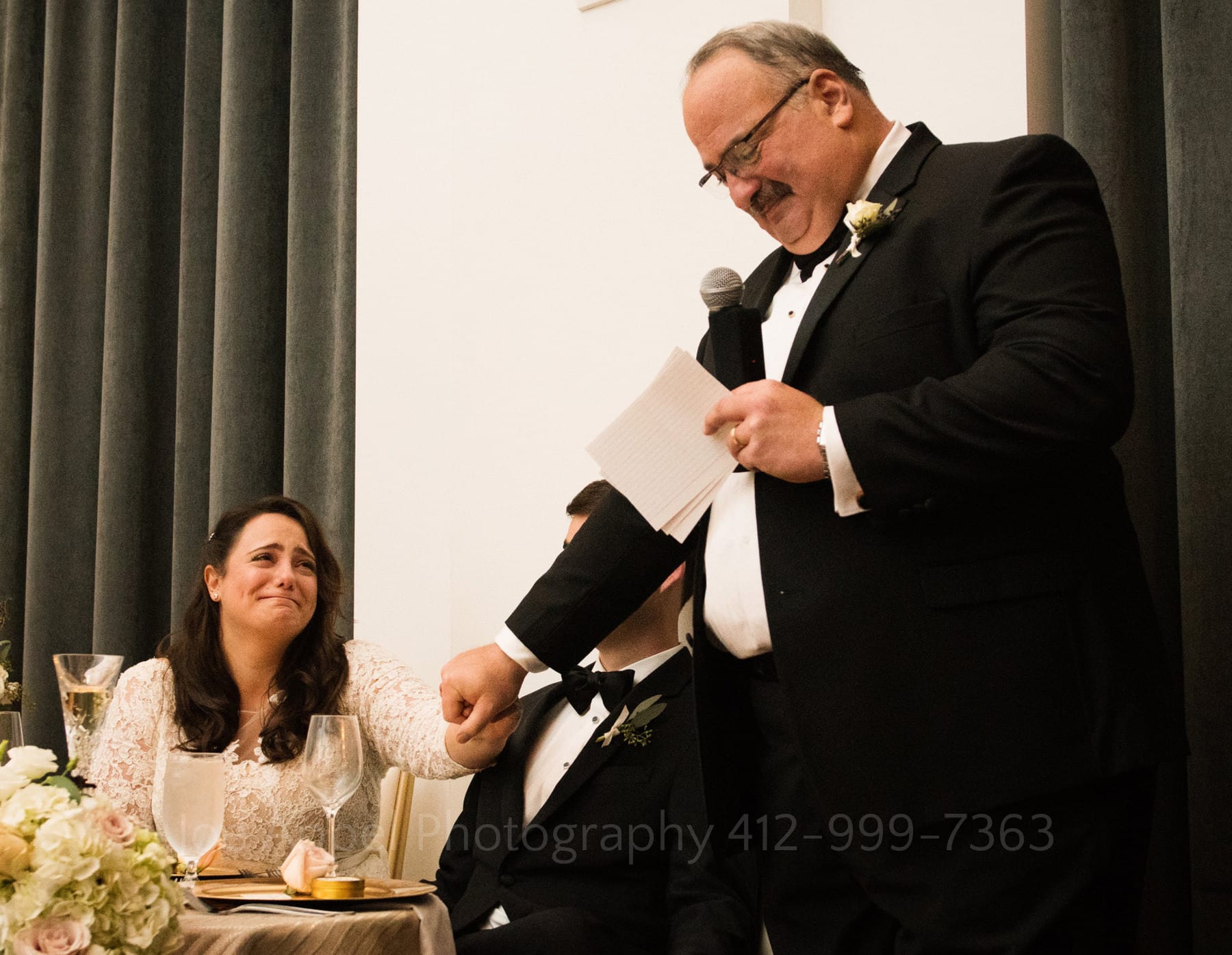 a bride cries as her father gives a speech while holding her hand during a hotel monaco pittsburgh wedding