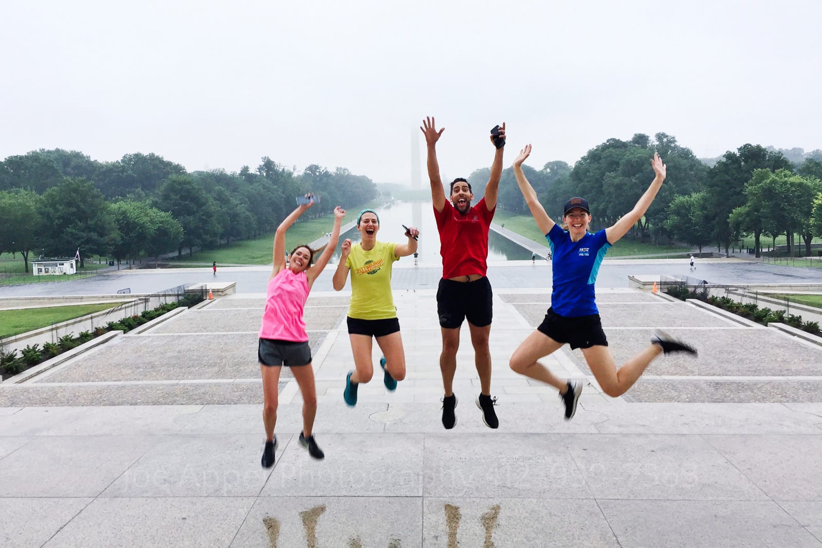 Four runners leap into the air on the steps of the Lincoln Memorial in Washington DC.