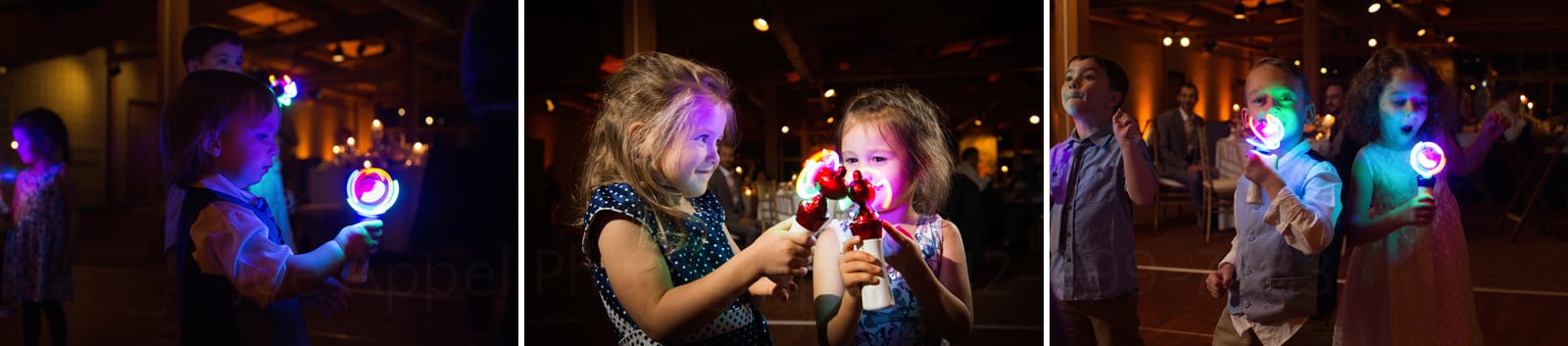 Small children are fascinated by brightly lighted whirligigs during a wedding reception. 