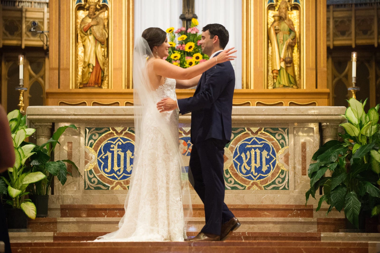A bride and groom embrace on the altar during their Wedding Photography at Fairmont Hotel Pittsburgh.