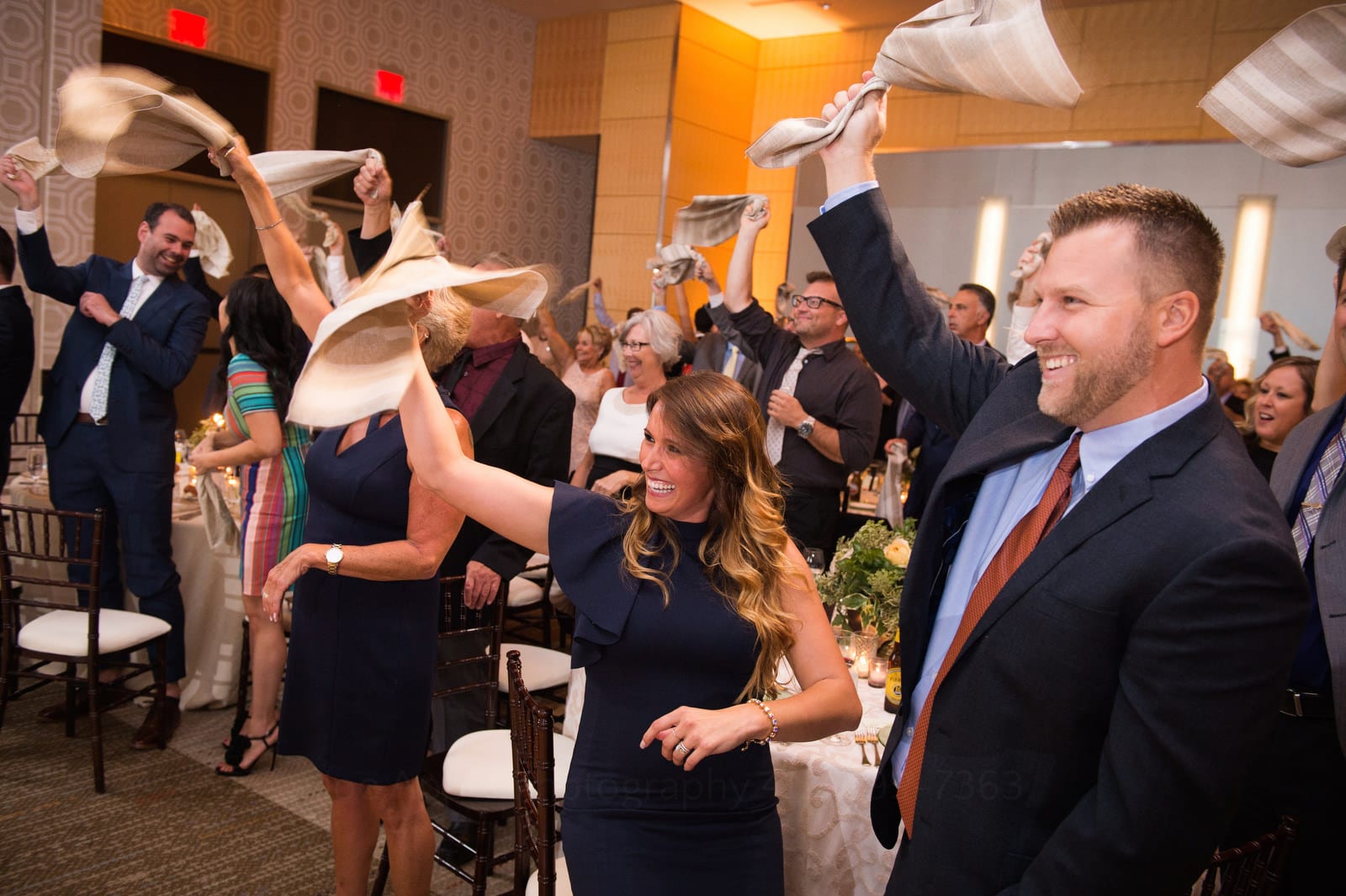 Smiling guests waving napkins above their heads during a Wedding Photography at Fairmont Hotel Pittsburgh.