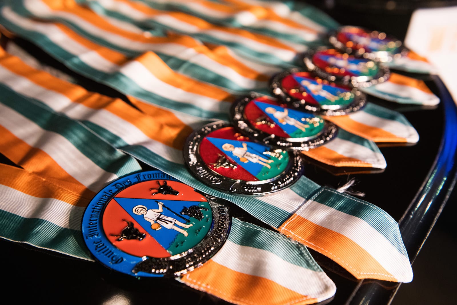 Medals with green, white, and orange ribbons are arrayed on top of a piano Pittsburgh editorial event photographer.