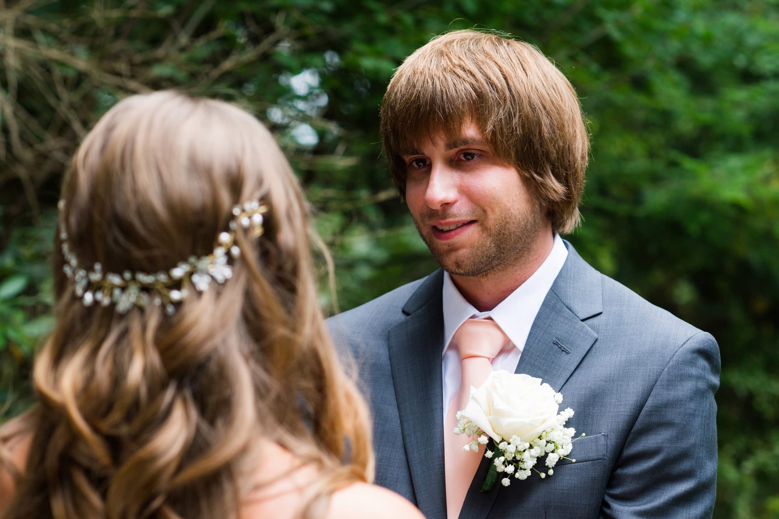 A groom in a blue suit looks at his bride while exchanging vows during their Hyeholde Wedding Pittsburgh.