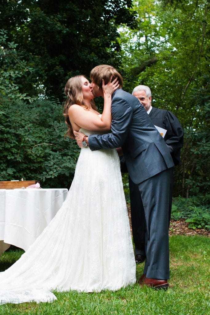 A bride and groom kiss at the end of their outdoor ceremony during their Hyeholde Wedding Pittsburgh.