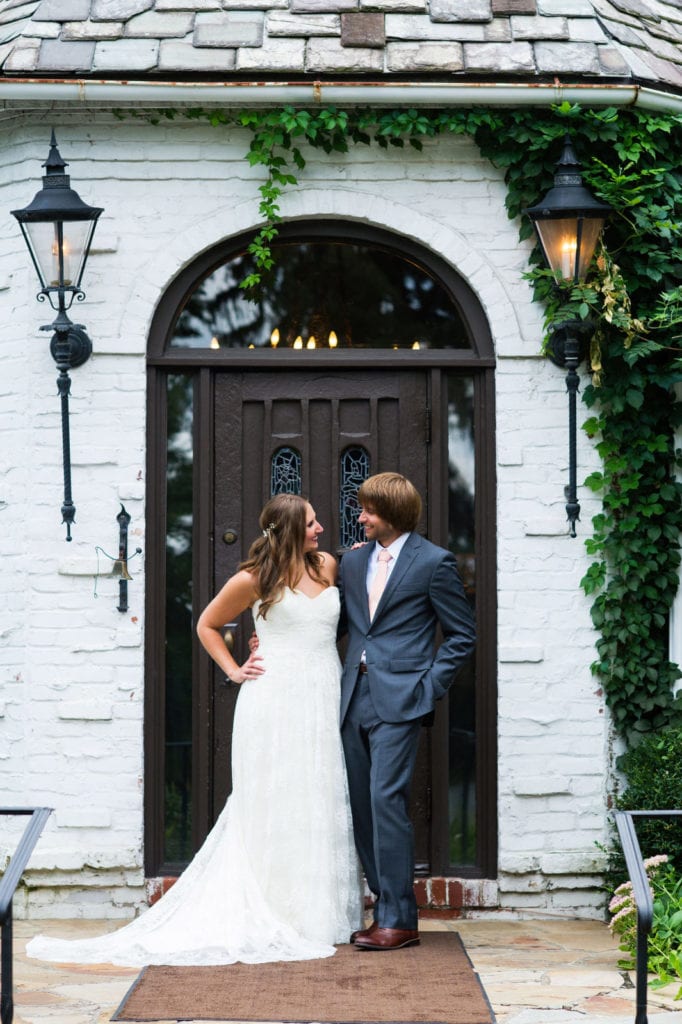 A bride and groom stand in front of the brown wooden door that leads into their Hyeholde Wedding Pittsburgh.