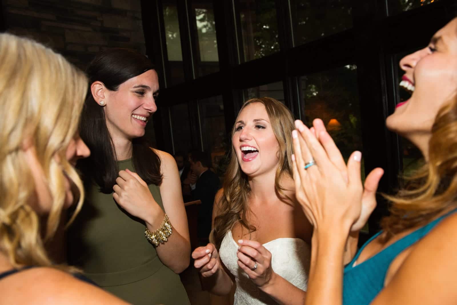 A bride smiles as she is surrounded by her women friends during her Hyeholde Wedding Pittsburgh.