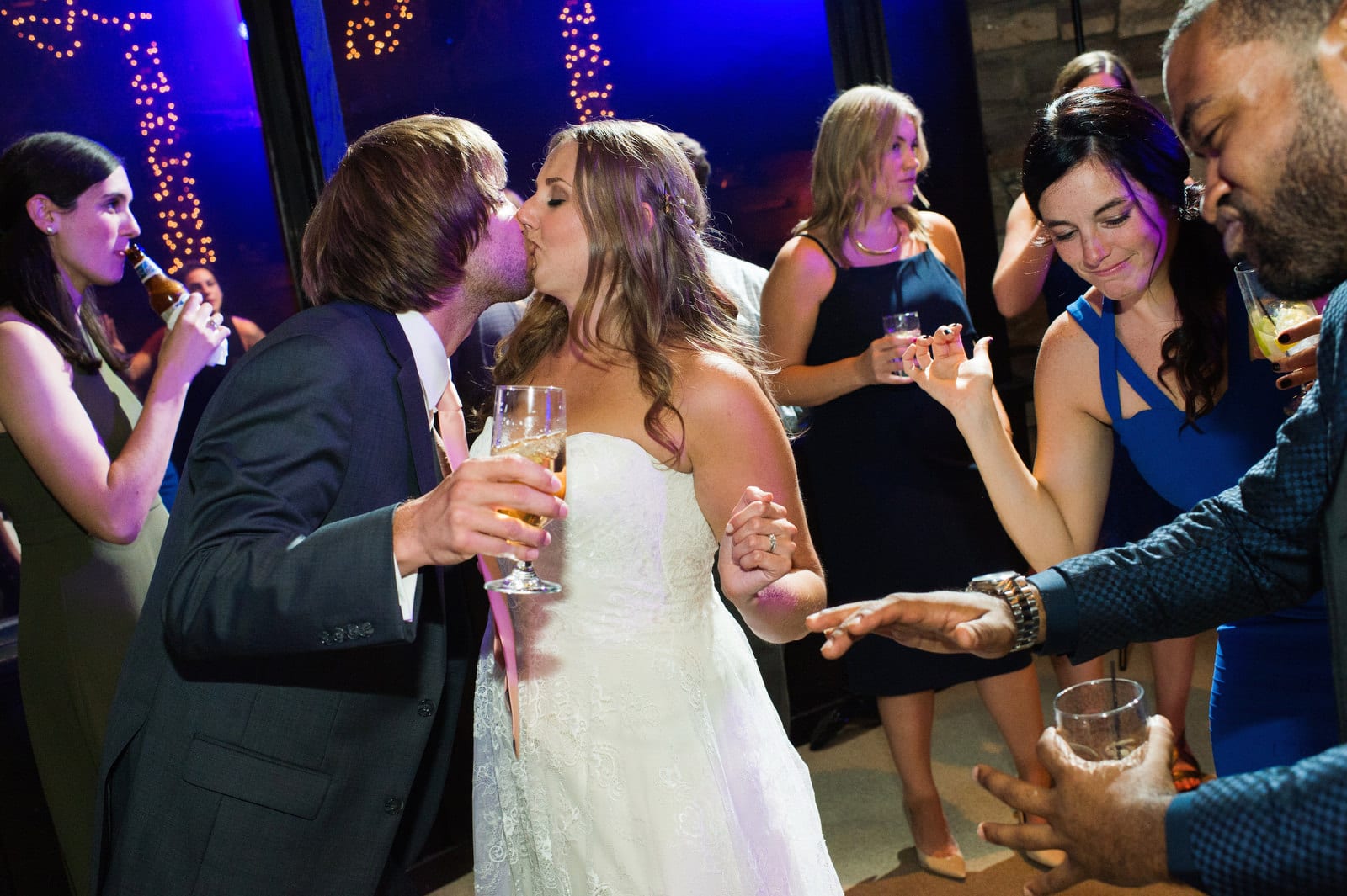 A bride and groom kiss on the dancefloor while surrounded by friends at their Hyeholde Wedding Pittsburgh.