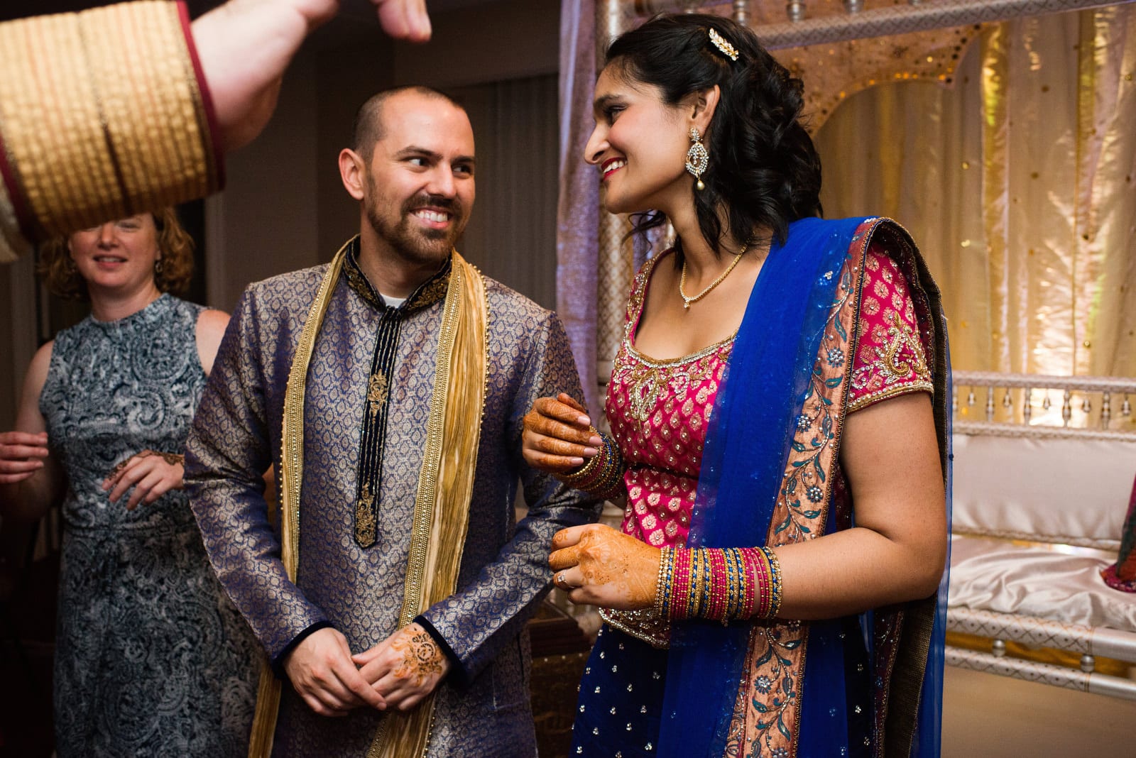 A bride and groom link arms as they dance wearing traditional Indian clothing during their Renaissance Phipps South Asian Wedding.