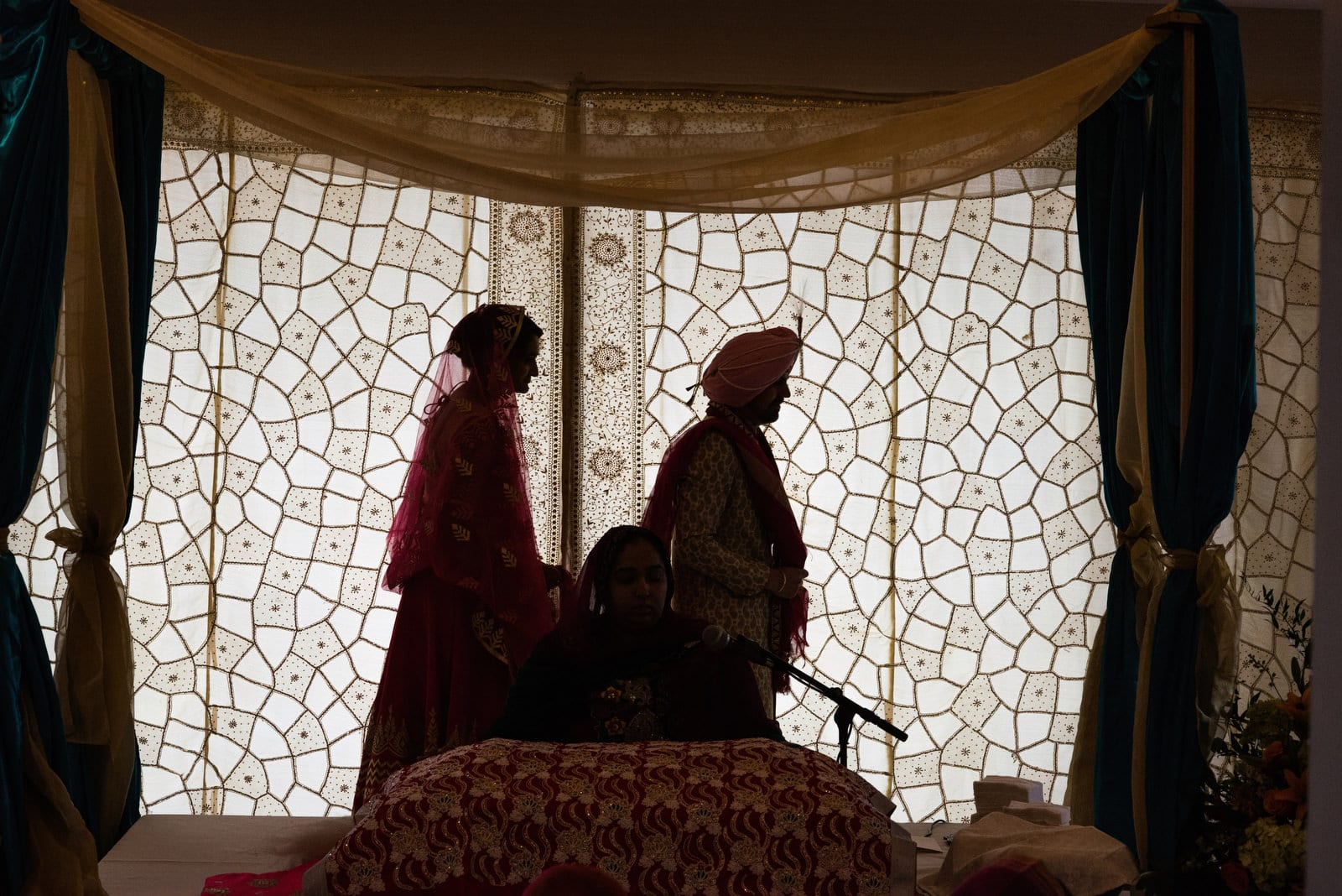 A silhouette of a groom leading his bride as they walk around the officiant during their Renaissance Phipps South Asian Wedding.