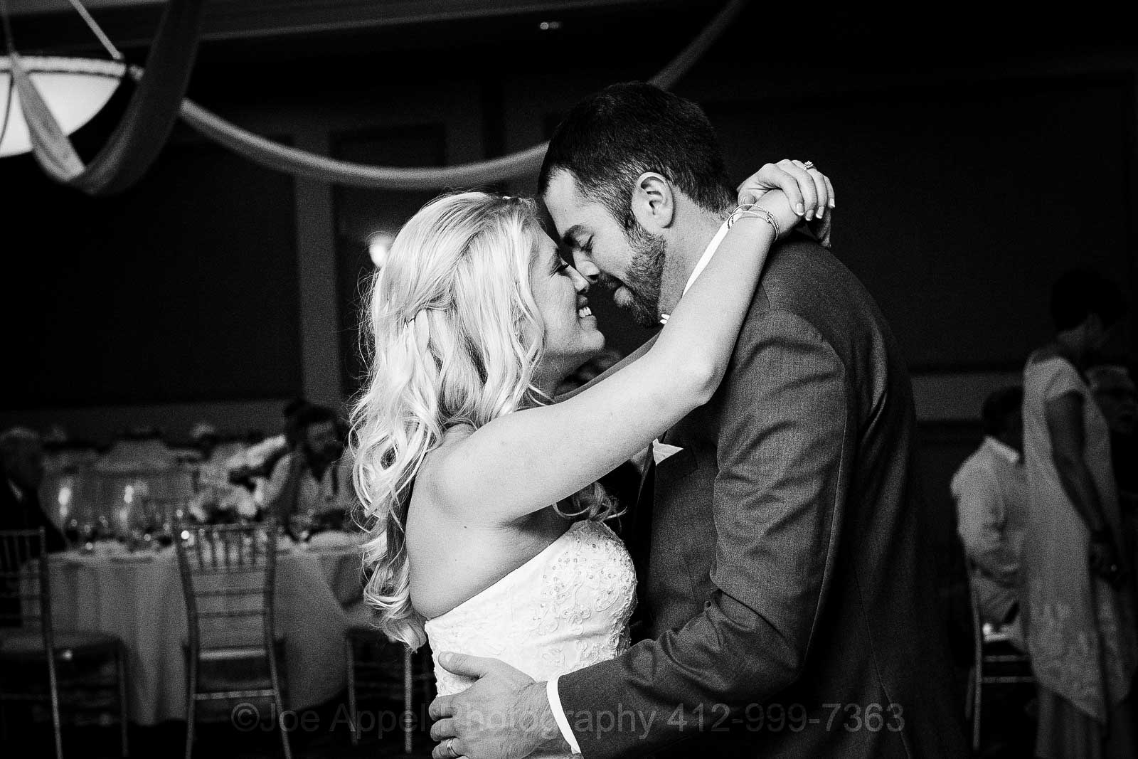 A bride and groom smash noses together as they share their first dance at their Embassy Suites Pittsburgh wedding.