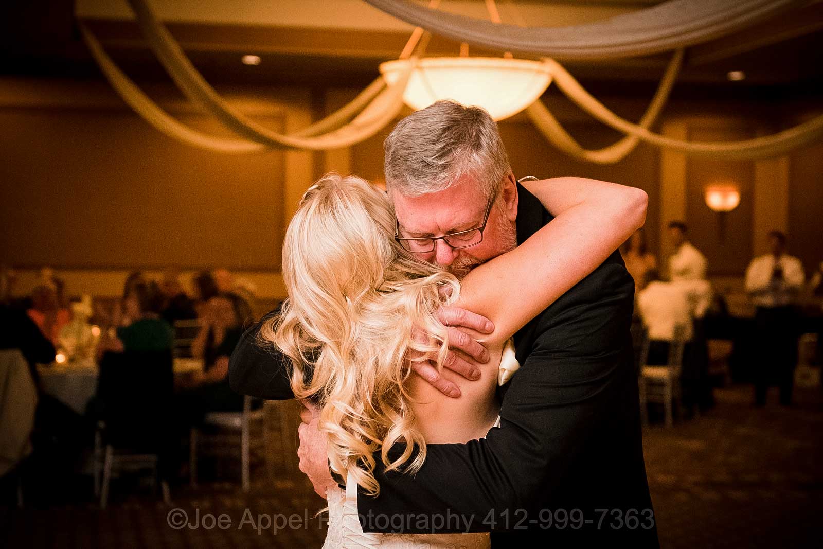 A bride embraces her father as they dance during her wedding reception at the Embassy Suites hotel near Pittsburgh International Airport.
