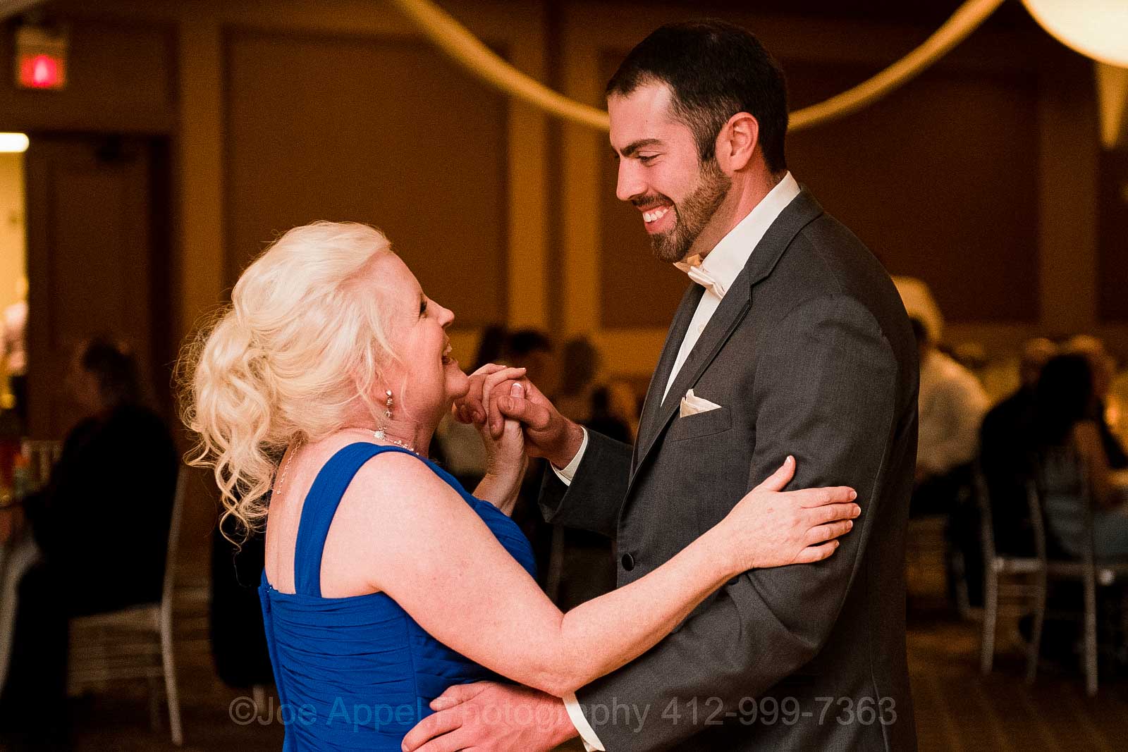 A groom dances with his mother, who is wearing a blue dress, during his wedding reception at the Embassy Suites hotel in Pittsburgh.