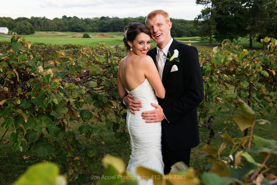 A bride and groom stand in the vineyard before Montour Heights Country Club wedding